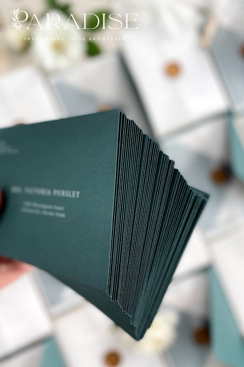 Stack of emerald envelopes with address printing showing consistent color, structured paper stock, and polished presentation for luxury wedding stationery.