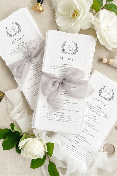 Add timeless romance to your table with our handmade paper wedding menus, tied with soft silk bows for an ethereal fine-art look. Crafted from cotton rag paper with delicate deckled edges, each menu exudes understated luxury - perfect for elegant garden, estate, or romantic indoor weddings. Designed to complement any refined tablescape, these menus blend artisanal craftsmanship with modern calligraphy and soft neutral tones for an effortlessly graceful presentation.