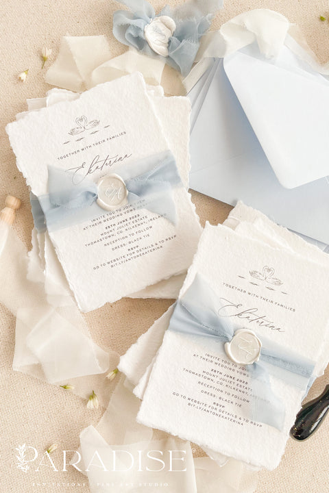 Delicate, timeless, and effortlessly romantic - this handmade paper wedding invitation suite is the perfect blend of fine art elegance and heartfelt simplicity. Printed on luxury deckled-edge cotton paper, each invitation exudes artisanal charm, its softly torn edges and tactile texture embodying the beauty of handcrafted design. Tied with a dusty blue silk ribbon and sealed with a white wax monogram, this suite radiates an ethereal calm - a whisper of something classic and pure. 