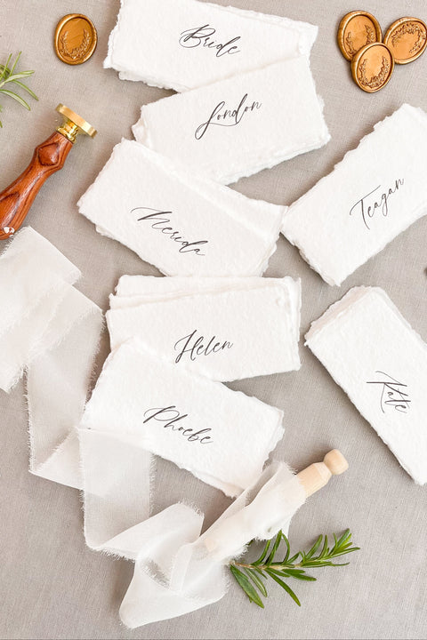 Elevate your tablescape with our handmade paper place cards, crafted from luxurious cotton rag paper and finished with naturally torn deckled edges. Each card features elegant modern calligraphy and a soft fine-art texture, making them the perfect addition to weddings, intimate dinners, bridal showers, or elevated celebrations. These artisan-made cards bring timeless beauty, organic character, and refined simplicity to any event setting.