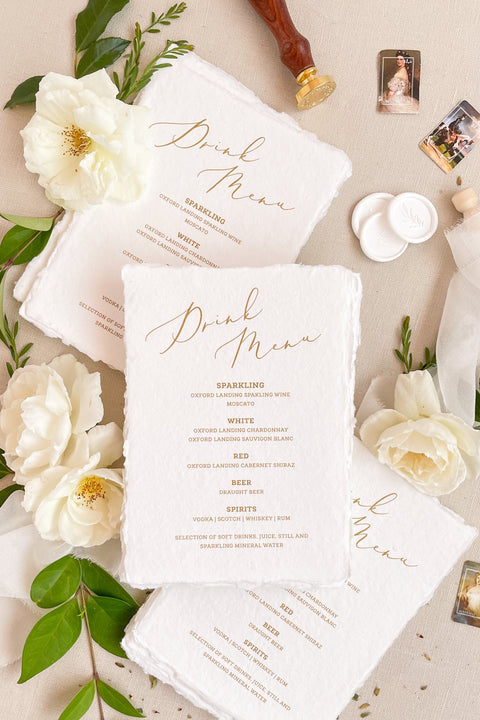 Add warmth and refinement to your bar or reception with our handmade paper drink menus. Crafted from 100% cotton paper with natural deckled edges and elegant gold calligraphy, these fine-art menus elevate any wedding table. Perfect for timeless, romantic, and luxury celebrations, each piece blends artisanal texture with sophisticated design.