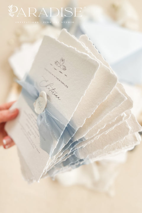 Delicate, timeless, and effortlessly romantic - this handmade paper wedding invitation suite is the perfect blend of fine art elegance and heartfelt simplicity. Printed on luxury deckled-edge cotton paper, each invitation exudes artisanal charm, its softly torn edges and tactile texture embodying the beauty of handcrafted design. Tied with a dusty blue silk ribbon and sealed with a white wax monogram, this suite radiates an ethereal calm - a whisper of something classic and pure. 