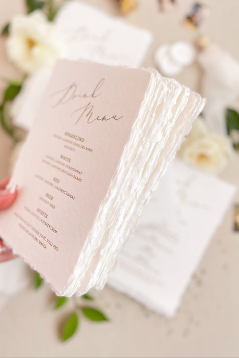 Add warmth and refinement to your bar or reception with our handmade paper drink menus. Crafted from 100% cotton paper with natural deckled edges and elegant gold calligraphy, these fine-art menus elevate any wedding table. Perfect for timeless, romantic, and luxury celebrations, each piece blends artisanal texture with sophisticated design.
