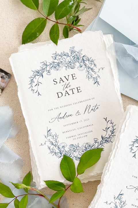 Invite your guests with timeless elegance using our handmade paper Save the Date cards, featuring a delicate blue floral wreath design inspired by fine art botanicals. Each card is printed on luxurious 100% cotton handmade paper with natural deckled edges, creating a soft, organic texture that perfectly complements romantic and refined wedding styles.