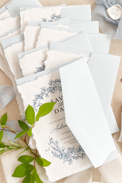 Invite your guests with timeless elegance using our handmade paper Save the Date cards, featuring a delicate blue floral wreath design inspired by fine art botanicals. Each card is printed on luxurious 100% cotton handmade paper with natural deckled edges, creating a soft, organic texture that perfectly complements romantic and refined wedding styles.