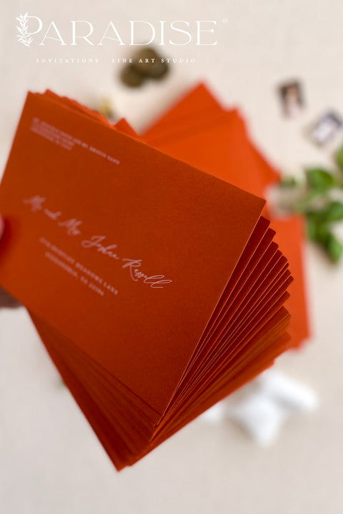 Close-up of red envelope with printed guest address, highlighting smooth paper texture, crisp lettering, and refined stationery craftsmanship.