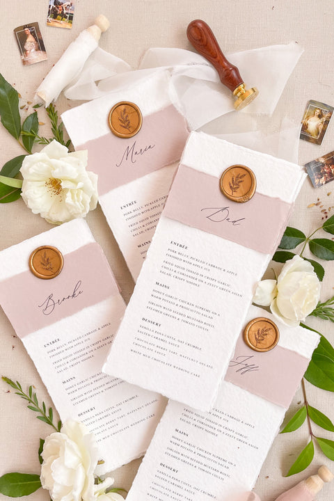 Add a romantic and refined touch to your reception with our handmade paper wedding menus, featuring dusty rose accents and gold wax seals. Each piece is crafted on luxury cotton paper with soft deckled edges, blending timeless charm with contemporary elegance - perfect for fine art or garden-inspired weddings. These menus effortlessly elevate your table styling, creating a cohesive and sophisticated dining experience.