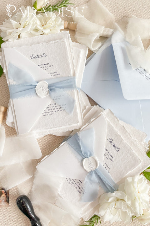 Elegant, romantic, and handmade with love - our fine art wedding invitation suite is crafted from luxury cotton deckled-edge paper and finished with a delicate powder blue chiffon ribbon and white wax seal. The soft blue tones and artisanal textures make this suite perfect for fine art, coastal, or destination weddings, offering a serene yet refined aesthetic that feels effortlessly graceful.