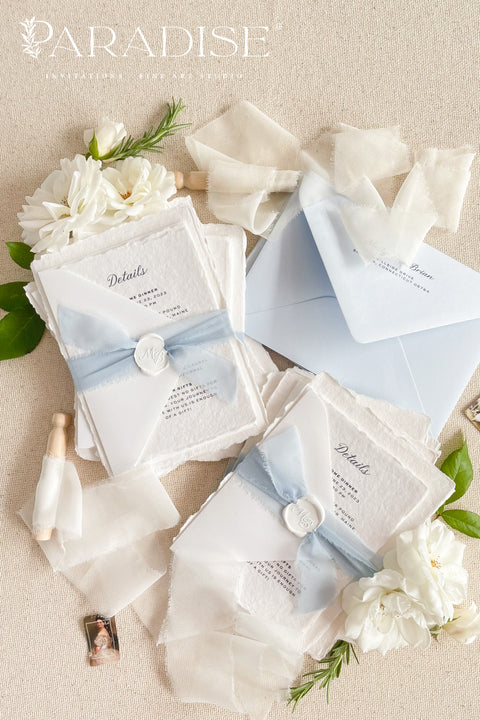 Elegant, romantic, and handmade with love - our fine art wedding invitation suite is crafted from luxury cotton deckled-edge paper and finished with a delicate powder blue chiffon ribbon and white wax seal. The soft blue tones and artisanal textures make this suite perfect for fine art, coastal, or destination weddings, offering a serene yet refined aesthetic that feels effortlessly graceful.