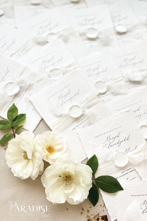 Elegant, refined, and crafted by hand - our handmade wedding invitation suite captures the essence of modern romance. Printed on 100% cotton deckled-edge paper, each invitation is delicately tied with an ivory chiffon ribbon and sealed with a white wax monogram, creating an heirloom piece that feels soft, timeless, and beautifully personal.