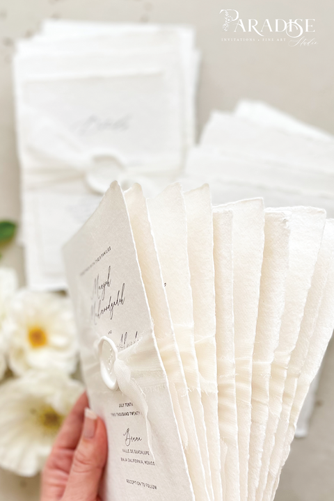 Elegant, refined, and crafted by hand - our handmade wedding invitation suite captures the essence of modern romance. Printed on 100% cotton deckled-edge paper, each invitation is delicately tied with an ivory chiffon ribbon and sealed with a white wax monogram, creating an heirloom piece that feels soft, timeless, and beautifully personal.